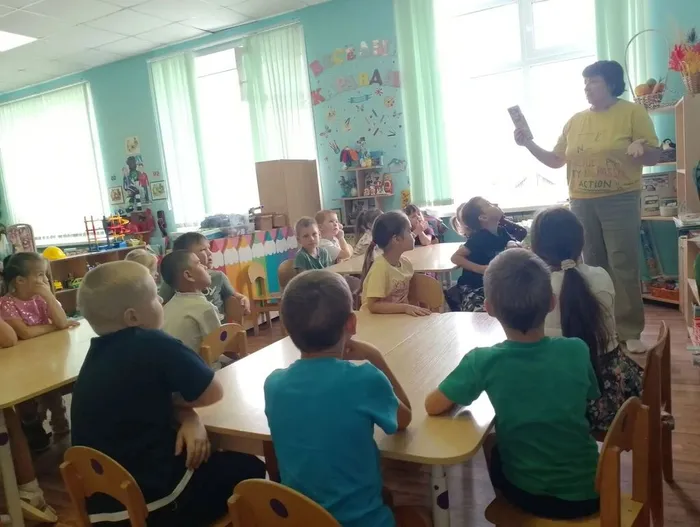 Библиотекарь показывает ребятам миниатюрные книжки