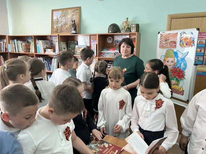 Библиотекарь проводит для детей обзор выставки