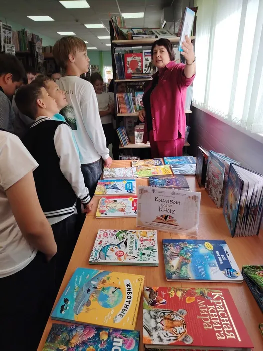 Библиотекарь проводит обзор книжной выставки Караван книг для учащихся