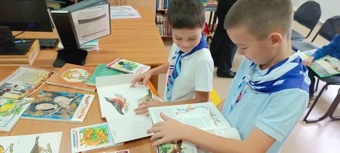 Ребята рассматривают книжную выставку о птицах